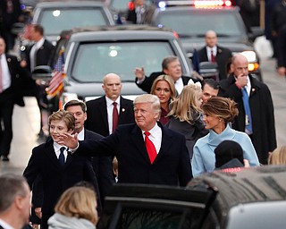 President Donald Trump, his wife Melania Trump and son Barron Trump walk along the inauguration day parade route in Washington, Friday, Jan. 20, 2017, after he was sworn in as the 45th president of the United States. (AP Photo/Carolyn Kaster)