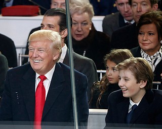 President Donald Trump smiles with his son Barron as they view the 58th Presidential Inauguration parade for President Donald Trump in Washington. Friday, Jan. 20, 2017 (AP Photo/Pablo Martinez Monsivais)