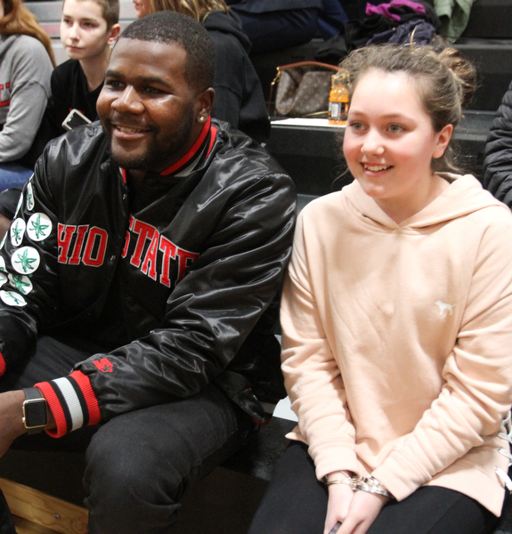 William D. Lewis The Vindicator Former OSU standout Cardale Jones poses  shot with Olivia Booth 12, of McDonald.  Her sister,Anna Booth(8th grade) ,was recently was diagnosed with cancer. Jones visited Mondays McDonald at Mineral Ridge game to show support for Anna who didn't attend the game. Jones visited her at her McDonald home before the game.