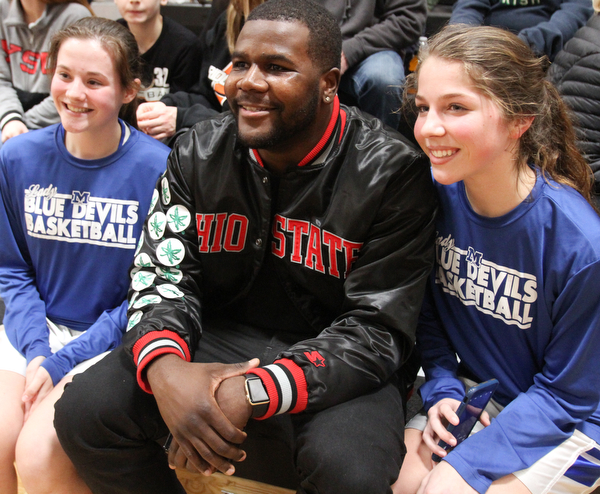 William D. Lewis The Vindicator Former OSU standout Cardale Jones poses for a  shot with members of the McDonald HS Jr High girls basketball team Emily Pratt, left, and Brooke Lewis. One of the team members Anna Booth(8th grade) was recently was diagnosed with cancer. Jones visited Mondays McDonald at Mineral Ridge game to show support for Anna who didn't attend the game. Jones visited her at her McDonald home before the game.