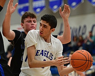 HUBBARD, OHIO - JANUARY 24, 2016: Bashar Rasoul #5 of Hubbard looks to pass the ball under the basket while being pressured by Drew Munno #22 of Lakeview during the first half of their game Tuesday night at Hubbard High School. DAVID DERMER | THE VINDICATOR