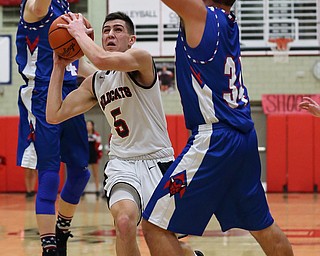 MICHAEL G TAYLOR | THE VINDICATOR- 01-28-17 -Basketball-  1st qtr., Struther's #5 Andrew Carbon splits Reserve's #34 Jack Cappabianca and #24 (left) Kade Hilles for the score.  Western Reserve Blue Devils  vs Struthers Wildcats at Struthers High School in Struthers Fieldhouse, Struthers, OH..