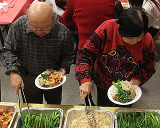 Bob Lee(left) and Anna Hom(right) plate Chinese Broccoli and SautŽed Rice Noodles during the Chinese New Year Celebration at Poland United Methodist Church in Poland on Sunday, Jan. 29, 2017. ..(Nikos Frazier | The Vindicator)..