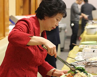Min He of Cortland plates some Chinese Broccoli during the Chinese New Year Celebration at Poland United Methodist Church in Poland on Sunday, Jan. 29, 2017. ..(Nikos Frazier | The Vindicator)..