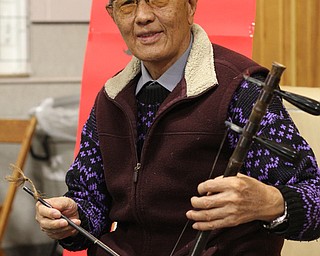 Xu Shougjiang, 81, of Xinjiang, China poses for a photo before performing at a Chinese New Year Celebration at Poland United Methodist Church in Poland on Sunday, Jan. 29, 2017. Shougjiang taught himself how to play the two string Chinese fiddle, the Jinghu, by listening to music on the radio. .(Nikos Frazier | The Vindicator)..