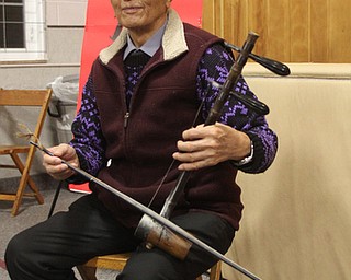 Xu Shougjiang, 81, of Xinjiang, China poses for a photo before performing at a Chinese New Year Celebration at Poland United Methodist Church in Poland on Sunday, Jan. 29, 2017. Shougjiang taught himself how to play the two string Chinese fiddle, the Jinghu, by listening to music on the radio. .(Nikos Frazier | The Vindicator)..