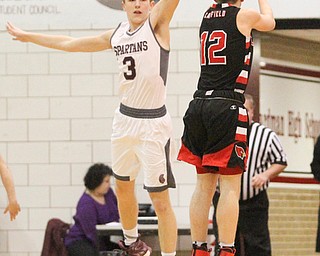 Canfield junior guard Ethan Kalina(12) as Boardman junior guard Holden Lipke(3) tries to block the shot during the first quarter as Canfield High School takes on Boardman High School at Boardman High School  in Boardman on Tuesday, Jan. 31, 2017. Boardman won 51-44...(Nikos Frazier | The Vindicator)..