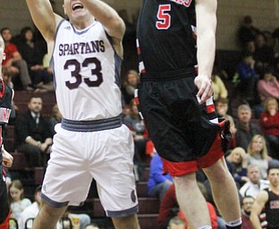 Canfield junior guard Tyler Dobrindt(5) goes up to block Boardman junior guard Dom Stilliana(33)'s shot during the second quarter as Canfield High School takes on Boardman High School at Boardman High School  in Boardman on Tuesday, Jan. 31, 2017. Boardman won 51-44...(Nikos Frazier | The Vindicator)..