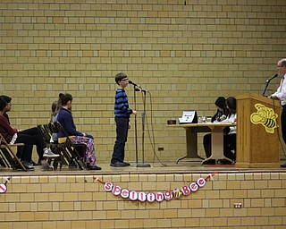 Neighbors | Abby Slanker.A Canfield Village Middle School student took his turn at the microphone and looked to Youngstown State University English professor Jeffrey Buchanan to pronounce his word to spell during the school’s annual Spelling Bee on Dec. 21.