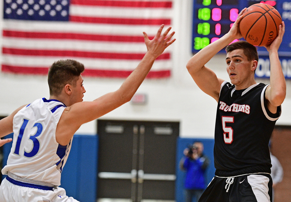 POLAND, OHIO - FEBRUARY 3, 2017: Andrew Carbon #5 of Struthers looks to pass the ball while being pressured by Brandon Barringer #13 of Poland during the first half of their game Friday night at Poland High School. DAVID DERMER | THE VINDICATOR