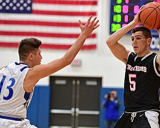 POLAND, OHIO - FEBRUARY 3, 2017: Andrew Carbon #5 of Struthers looks to pass the ball while being pressured by Brandon Barringer #13 of Poland during the first half of their game Friday night at Poland High School. DAVID DERMER | THE VINDICATOR