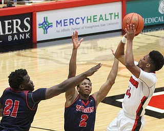 Youngstown State Penguins junior guard Cameron Morse(24) goes up for two as Detroit Mercy senior guard Patrick Robinson Jr.(2) and junior forward Jaleel Hogan(21) during the first half as Detroit Mercy University takes on Youngstown State at the Beeghly Center at Youngstown State University in Youngstown on Saturday, Feb. 4, 2017. Detroit Mercy won, 90-80...(Nikos Frazier | The Vindicator)..