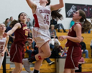 MICHAEL G TAYLOR | THE VINDICATOR- 02-04-17 -Basketball-  2nd qtr., Columbiana's #15 Kennedy Fullum, splits the defense of Mooney's #14 Camden Hergenrother (right) and #11 Courtney Koken (left) for the score.  Lady Basketball- Cardinal Mooney vs Columbiana Clippers at Columbiana High School in Richard Berryman Gymnasium, Columbiana,, OH