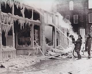 Mute testimony in ice -- Total destruction results from the suspected arson blaze that destroyed the Blood, Sweat and Tears Lounge at Wilson Ave and Center Street early today. Bone chilled firemen continue to direct a stream of water on the still smoldering ruins in the loss that is estimated to be $35,000 fir the building alone.