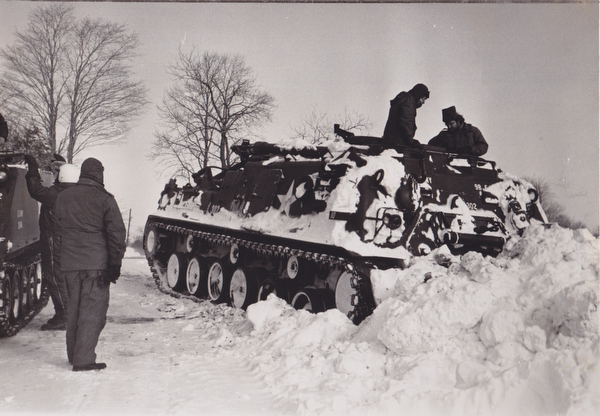 Balky Tank Retriever -- Crewmen work on the Ohio National Guard's big M88 Tank Retriever, disabled with a frozen battery. The big vehicle, brought to Salem from Ravenna, was to have cleared snow-closed roads in the Salem area. The monster's failure to start disappointed newspeople on hand for the run.