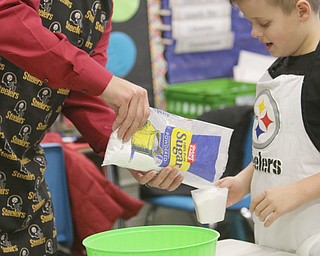       ROBERT K. YOSAY  | THE VINDICATOR..Gavin English wih his dad (supervisor)  Ken  carefully measure sugar together ..Hot Chocolate production in Kristin Hartshorn 3rd grade class - was at peak production on thursday afternoon as packets of Hot Chocolate .  starting with ingredients and ending up in take home bags at a buck and a half ...-30-.