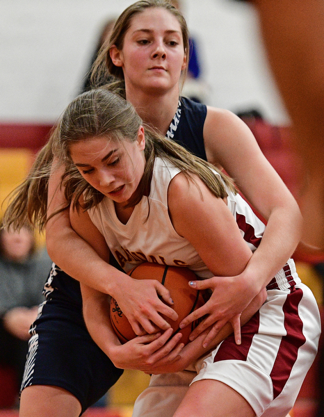 YOUNGSTOWN, OHIO - FEBRUARY 6, 2017: Camden Hergencothen #14 of Mooney secures the ball while being fouled by Sam Homa #12 of McDonald after blocking her shot during the first half of their game Monday night at Cardinal Mooney High School. DAVID DERMER | THE VINDICATOR