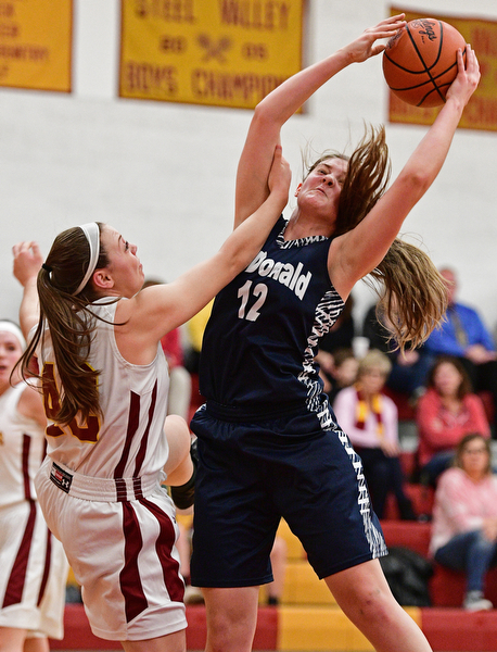 YOUNGSTOWN, OHIO - FEBRUARY 6, 2017: Sam Homa #12 of McDonald grabs a rebound by Concetta Rinaldi #42 of Mooney during the first half of their game Monday night at Cardinal Mooney High School. DAVID DERMER | THE VINDICATOR