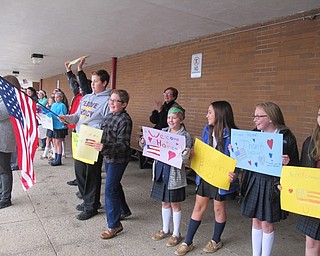 Neighbors | Alexis Bartolomucci.Students from St. Christine School lined up with flags and welcome signs for a student's father who is in the Navy and came back from the Middle East to surprise his son.