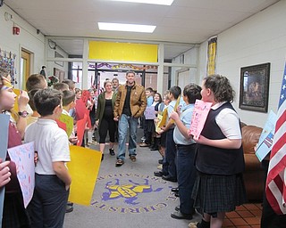 Neighbors | Alexis Bartolomucci.Jason and Jana Davis walked into the St. Christine School as students held up signs and flags to welcome him back.