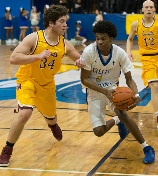 MICHAEL G TAYLOR | THE VINDICATOR- 02-11-17  -Basketball-  3rd qtr., YVC #0 Emmanuel Armour drives to the hoop against Mooney's #34 Vinny Gentile. Cardinal Mooney vs Youngstown Valley Christian Eagles at Youngstown Valley Christian High School, Youngstown, OH.
