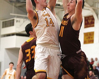 Pat Brennan(14) of Mooney goes up to the net as Dan Ritter(11) of South Range tries to block his shot during the first quarter as South Range High School takes on Cardinal Mooney High School at the Cardinal Mooney High School Gymnasium in Youngstown on Tuesday, Feb. 14, 2017.  South Range won 65-43..(Nikos Frazier | The Vindicator)..