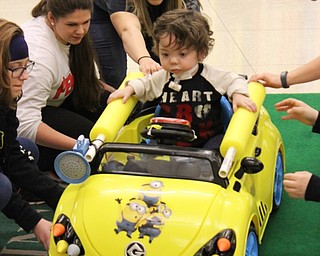 Neighbors | Abby Slanker.Members of Team Matthew helped him drive over an obstacle in the obstacle course set up for Go Baby Go at the Mahoning County Career and Technical Center on Jan. 21.