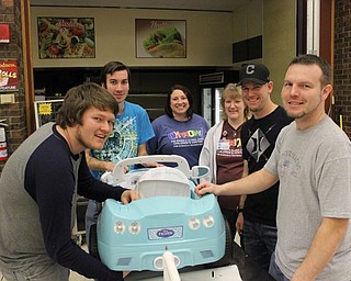 Team Guiliana, Wesley Gilbert (left), Andy Gretsinger, Beth Smith, Mary Ann Whitcher, Eric Pavlicko and Tom Hopkinson (right), were hard at work modifying Giuliana’s “Frozen” car to fit her perfectly at the Go Baby Go build at the Mahoning County Career and Technical Center on Jan. 21.
