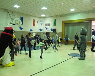 Neighbors | Alexis Bartolomucci.First-grade students and their families follow the instructions of Youngstown State University baseball players and personal trainer Jerry DeJane on how to do certain exercises during the Poland Union Family Health Night on Jan. 25.
