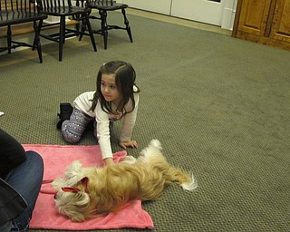 Neighbors | Alexis Bartolomucci.Julia pet Roxie, a therapy dog, at the Poland library on Jan. 31 as her sister read a book to Roxie.