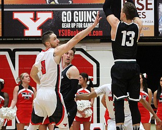 Wright State junior guard Grant Benzinger(13) goes up for three as Youngstown State Penguins senior forward Matt Donlan(0) reaches back to try and block the shot during the 1st half as Wright State University takes on Youngstown State University, Thursday, Feb. 16, 2017 at the Beeghly Center at Youngstown State University. Wright State won 84-81...(Nikos Frazier | The Vindicator)..