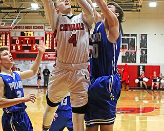 Canfield's Brandon McFall (4) attempts a layup while being defended by Poland's Daniel Kramer (10) during Friday nights matchup at Canfield High School.  Dustin Livesay  |  The Vindicator  2/17/17 Canfield High School.