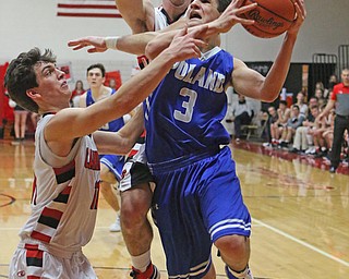 Poland/s Braeden O'Shaungnessey (3) goes up for a layup while being defended by Canfield's Jake Cummings (1) and Spencer Woolley (11) during Friday nights matchup at Canfield High School.  Dustin Livesay  |  The Vindicator  2/17/17 Canfield High School.