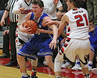 Poland's Kyle Paterson (30) tries to hold the ball while being double teamed by Canfield's Brandon McFall (4) and Zach Tinkey (21) during Friday nights matchup at Canfield High School.  Dustin Livesay  |  The Vindicator  2/17/17 Canfield High School.