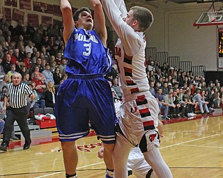Poland's Braeden O'Shaungnessey (3) puts up a shot while being defended by Canfield's Brandon McFall (4) during Friday nights matchup at Canfield High School.  Dustin Livesay  |  The Vindicator  2/17/17 Canfield High School.