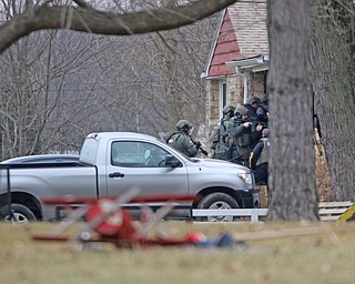        ROBERT K. YOSAY  | THE VINDICATOR..Swat team.. enters the house..GOSHEN Ñ Mahoning County Sheriff Jerry Greene said a suspect is dead from "apparent suicide" after shots were fired as deputies tried to serve a civil order of protection at about 11:20 a.m... .-30-