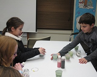 Neighbors | Alexis Bartolomucci.Children used different colored sand to make sand art molds and bracelets during the Geology Rocks program at Ford Nature Center on Feb. 4.