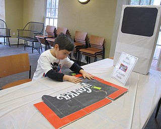 Neighbors | Alexis Bartolomucci.CJ worked and putting together the Mike Teevee Chocolate Puzzle during the Willy Wonka event at the Poland library on Feb. 11.