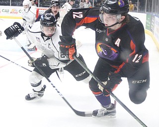 Phantoms forward Austin Pooley(12)(right) and Force forward Blake Lizotte(27)(left)  race towards a loose puck during the 2nd period as the Fargo Force take on the Youngstown Phantoms, Friday, Feb. 24, 2017 at the Covelli Centre in Youngstown. The Phantoms won 2-1 in OT...(Nikos Frazier | The Vindicator)..