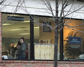 People watch from the window of Sleepy Hollow Sleep Shop after a shooting occurred just after 4:00 p.m. at a house on the 1500 block on Niles-Cortland Road, State Route 46, in Howland, Saturday, Feb. 25, 2017 in Howland. One subject died at the scene, another at the hospital later on, three others remain in the hospital...(Nikos Frazier | The Vindicator)..