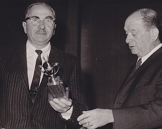 Jerold S. Meyer (left) receives a silver cup award for an outstanding performance as chairman of last year's United Negro College Fund Campaign. Presenting the award is Carroll,