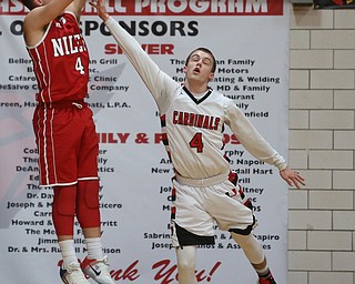 Niles sophomore guard Cyler Kane-Johnson(4) shoots for three as Canfield senior guard Brandon McFall tries to block his shot during the 1st quarter as Niles McKinley takes on Canfield, Tuesday, Feb. 28, 2017 at Canfield High School. Canfield won 70-42...(Nikos Frazier | The Vindicator)..