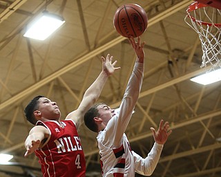 Canfield senior guard Brandon McFall(4)(right) goes up for a layup as Niles sophomore guard Cyler Kane-Johnson(4) reaches behind to try and stop the shot during the 1st quarter as Niles McKinley takes on Canfield, Tuesday, Feb. 28, 2017 at Canfield High School. Canfield won 70-42...(Nikos Frazier | The Vindicator)..