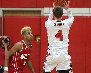 Canfield senior guard Brandon McFall(4) goes up for two as Niles senior forward Jasson Faison(3) watches on during the 2nd quarter as Niles McKinley takes on Canfield, Tuesday, Feb. 28, 2017 at Canfield High School. Canfield won 70-42...(Nikos Frazier | The Vindicator)..