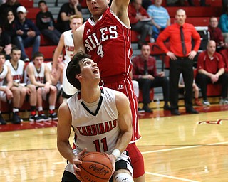 Canfield junior forward Spencer Woolley(11) looks up at the basket as Niles sophomore guard Cyler Kane-Johnson(4) tries to block his shot too early during the 3rd quarter as Niles McKinley takes on Canfield, Tuesday, Feb. 28, 2017 at Canfield High School. Canfield won 70-42...(Nikos Frazier | The Vindicator)..