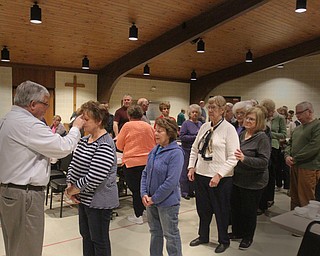 William D. Lewis The Vindicator Western Reserve United Methodist Church pastor Rev Russ Adams distributes ashes to parishioers.during an Ash Wednesday service at the Canfield Church.