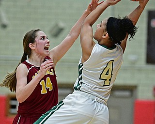 STRUTHERS, OHIO - MARCH 1, 2017: Nomiki Willis #4 of Ursuline makes a off balance pass while being pressured by Victoria Lyden #14 of Mooney during the second half of their tournament game Wednesday night at Struthers High School. DAVID DERMER | THE VINDICATOR