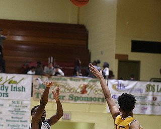 Dakota Hobbs(14) of Ursuline goes up for three as Jordan Stanford(35) of Cardinal Mooney tries to block his shot during the 3rd quarter as Cardinal Mooney takes on Ursuline, Friday, March 3, 2017 at Ursuline High School. Ursuline won 39-37...(Nikos Frazier | The Vindicator)..