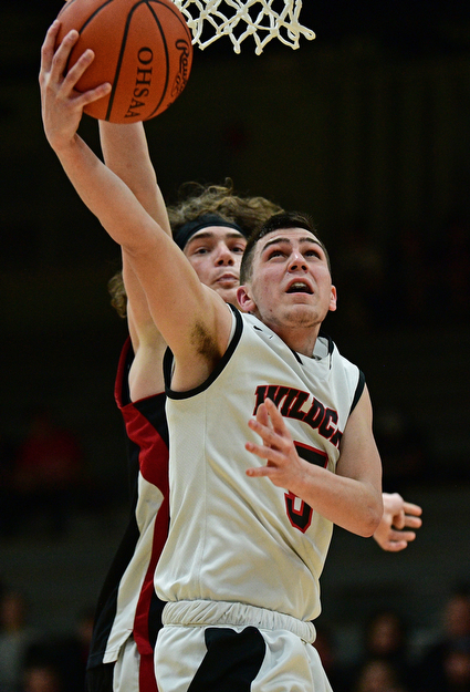 STRUTHERS, OHIO - MARCH 3, 2017: Andrew Carbon #5 of Struthers goes to the basket while being pressured from behind by Chase Ackerman #24 of Salem during the second half of their game Friday night at Struthers High School. DAVID DERMER | THE VINDICATOR