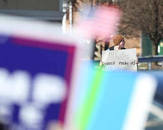 Daniel Thomas, 22, of Austintown holds a "Hate won't make us great" sign across the street from supporters of President Donald Trump as they hold flags and signs at the Summitville Tile parking lot on 224, Saturday, March 4, 2017 in Boardman. ..(Nikos Frazier | The Vindicator)..
